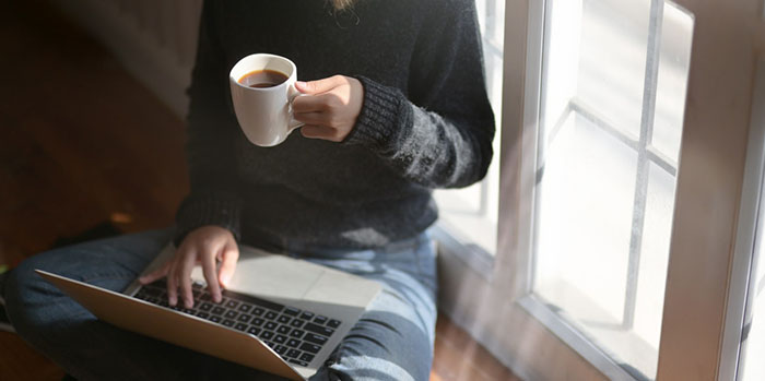 woman-using-laptop-while-holding-a-cup-of-coffee-3759083.jpg